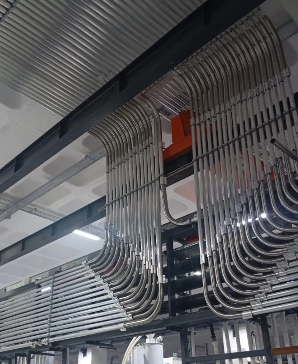 Stainless material conveying lines running along the ceiling